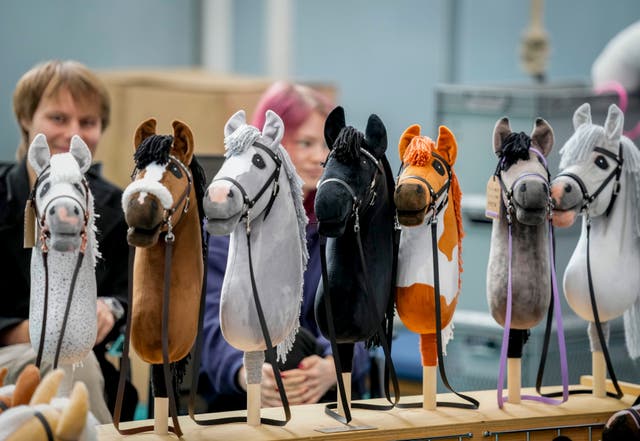 A vendor offers hobby horses for sale