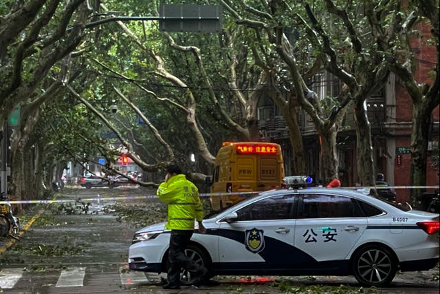 Policemen close a road in the aftermath of Typhoon Bebinca in Shanghai, China