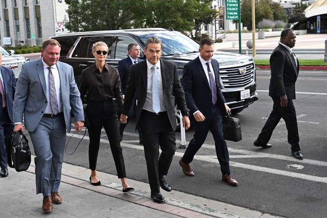 Lachlan Murdoch, centre, and his wife Sarah arrive at court