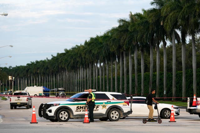 An officer with the Palm Beach County Sheriff’s office works outside  Trump International Golf Club in West Palm Beach, Florida