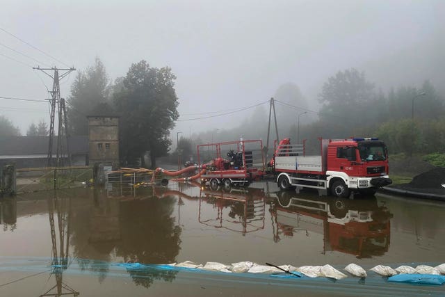 Firefighters pump water and mud from city streets and help clean the city of Głogow that was hit by a high flood wave in southwestern Poland 