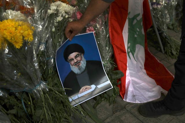 A poster of Hezbollah leader Hassan Nasrallah on flowers in front of the Lebanese Embassy in Tehran