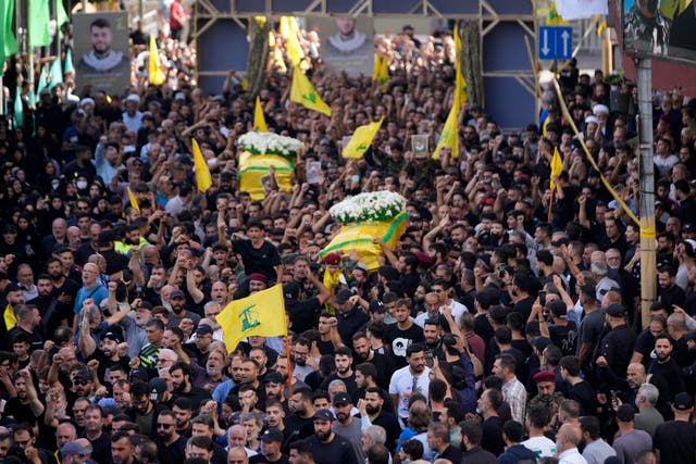 Hezbollah members carry the coffins of their comrades