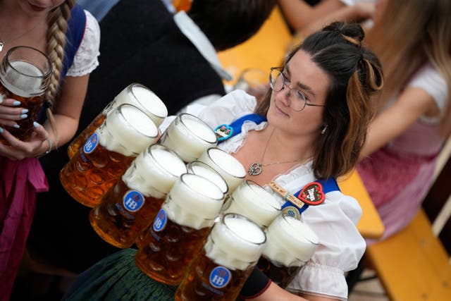 A waitress carries beer mugs in the Hofbraeuhaus tent