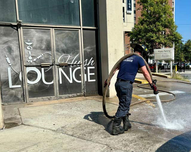 A firefighter cleans blood stains off the sidewalk outside a nightclub in Birmingham, Alabama 