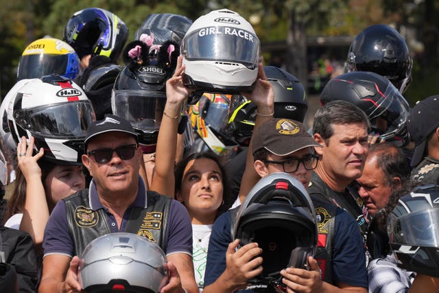 Faithful hold up their helmets to be blessed during the IX Pilgrimage of the Blessing of Helmets that draws tens of thousands at the Roman Catholic holy shrine of Fatima, in Fatima, Portugal