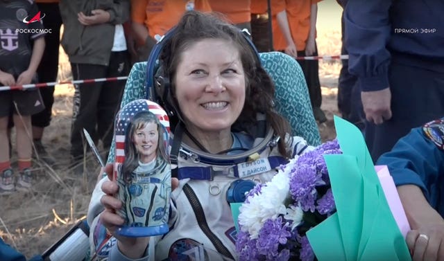 Nasa astronaut Tracy Dyson holds a Russian traditional Matryoshka wooden doll depicting her shortly after the landing of the Russian Soyuz MS-25 space capsule