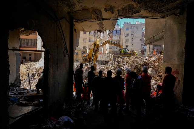 Emergency workers use excavators to clear the rubble at the site of Friday’s Israeli strike in Beirut’s southern suburbs