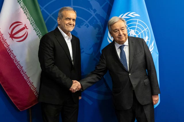 President of Iran Masoud Pezeshkian, left, and UN Secretary-General Antonio Guterres shake hands