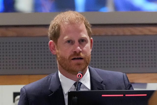 Harry in a shirt and tie on a lectern