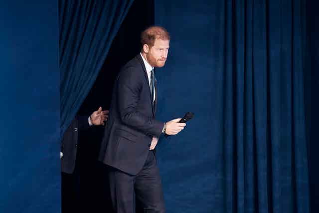 Harry walking through a curtain out on to the stage during the Clinton Global Initiative 