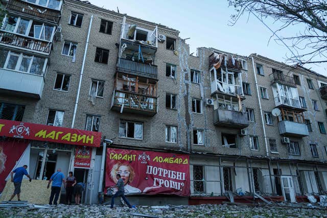 People clear the rubble in a front of a residential building heavily damaged in a Russian air strike in Kramatorsk, Donetsk region, Ukraine