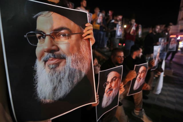 Lebanese and Palestinian men hold portraits of Hezbollah leader Sayyed Hassan Nasrallah, as they shout slogans during a protest against his assassination, in the southern port city of Sidon, Lebanon, Saturday, Sept. 28, 2024