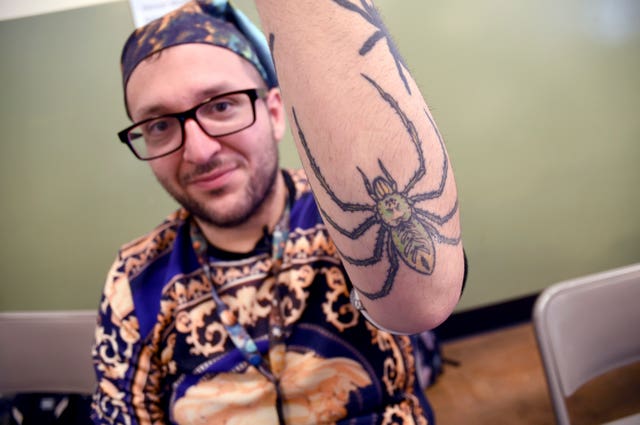 A man with spider tattoos on his arm