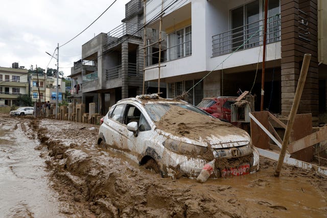 A car parked outside a building swamped in mud in Kathmandu 