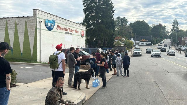 People wait to gather water 