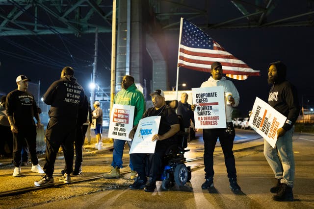 Boise Butler, president of Local 1291, with an American flag on his wheelchair, pickets with fellow longshoremen outside the Packer Avenue Marine Terminal Port in Philadelphia