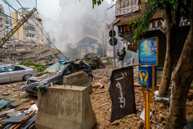 A man documents damaged buildings at the site of an Israeli airstrike in Beirut’s southern suburb