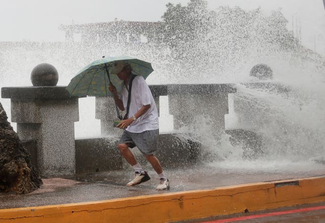 A man runs away from waves when he was walking along the shore in Kaohsiung