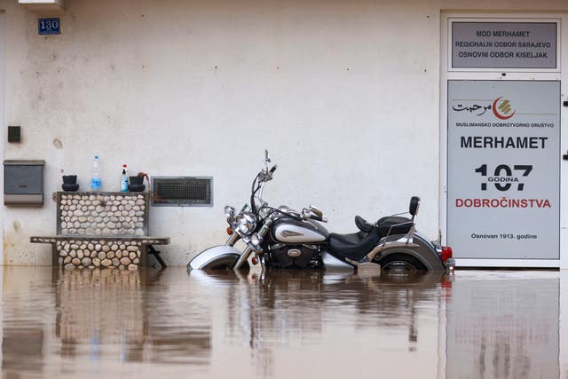 A motorcycle is partially submerged in floodwaters outside an apartment building in the village of Kiseljak, northern Bosnia