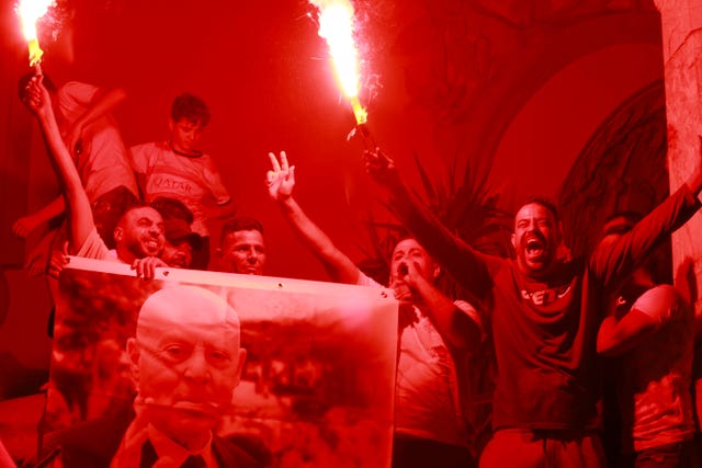 People celebrating and holding a poster of Tunisian president Kais Saied