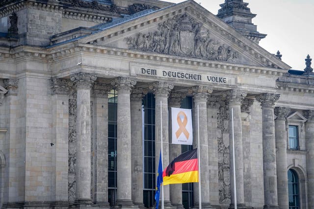 A commemorative ribbon with the inscription “October 7, 2023” hangs on the Reichstag building