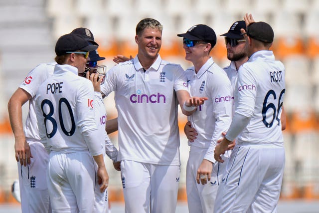 England’s Brydon Carse celebrates with team-mates around him after taking the wicket of Pakistan’s Naseem Shah