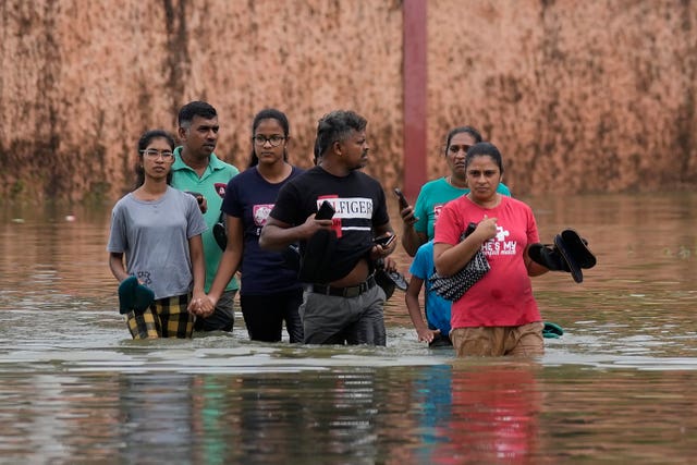 People wade through a flooded street