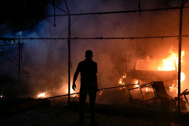 A man silhouetted against fire