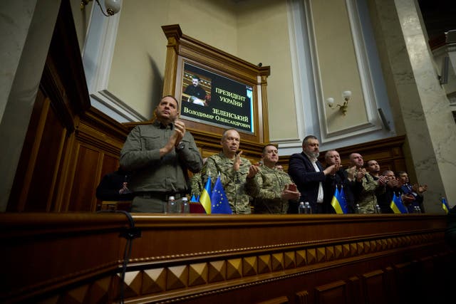 People applaud as they listen to a speech by Volodymyr Zelensky