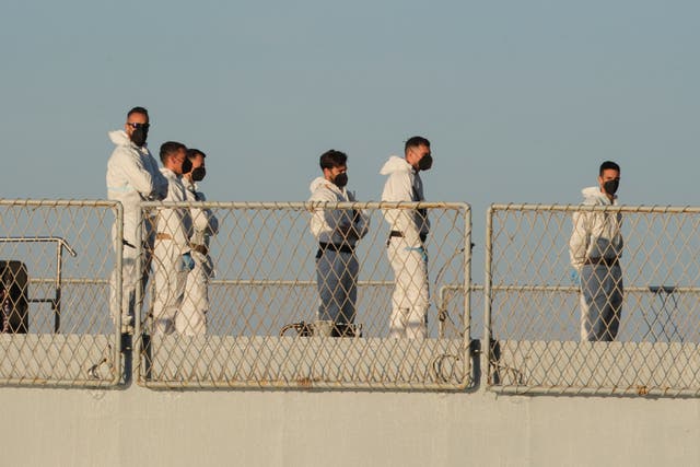 Security officials in white overalls