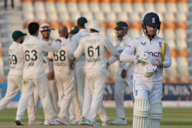 Ben Duckett walks off the pitch as Pakistan players celebrate his dismissal