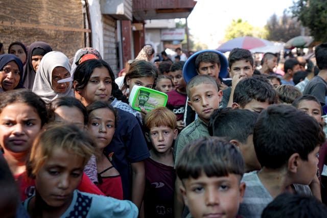 Palestinians line up for food distribution in Deir al-Balah