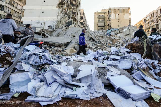 Documents of Hezbollah-run al-Qard al-Hassan are scattered at the site of an Israeli airstrike on Sunday night in Beirut