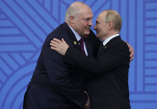 Russian President Vladimir Putin embracing Belarusian President Alexander Lukashenko