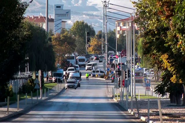 Emergency rescue teams and police officers work outside the building