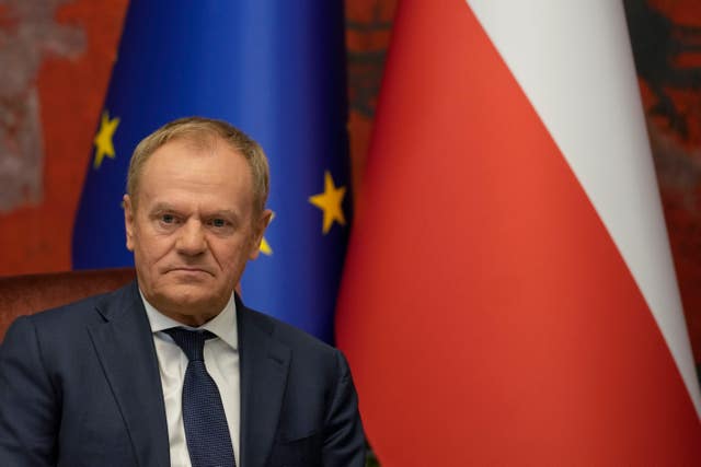 Donald Tusk sat before national flags