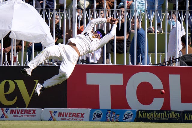 Saim Ayub dives backward while trying to take a catch near the boundary