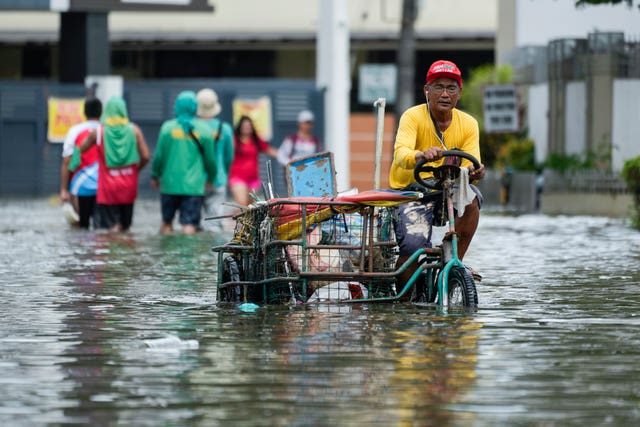 People fight their way through floodwaters