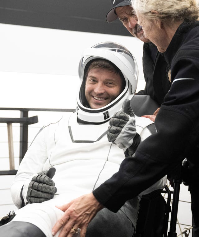 Matthew Dominick being helped out of the SpaceX Dragon Endeavour spacecraft