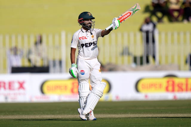 Pakistan batter Saud Shakeel raises his bat to celebrate his century