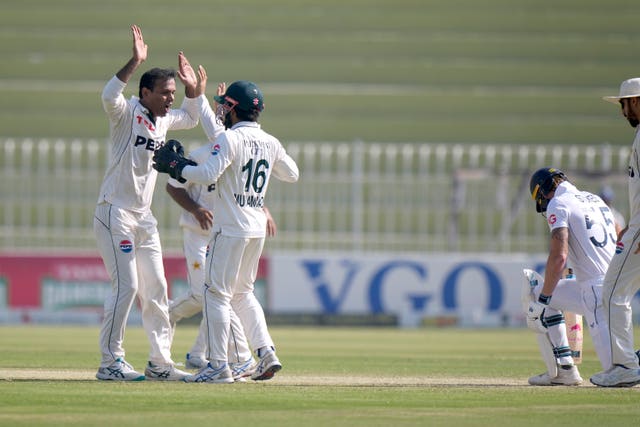 Pakistan’s Noman Ali, left, celebrates with team-mates after taking the wicket of England’s Ben Stokes 