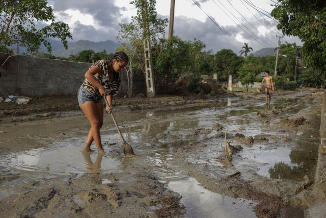 People try to remove mud from a street a week after Hurricane Oscar hit the town of Imias in Guantanamo province 