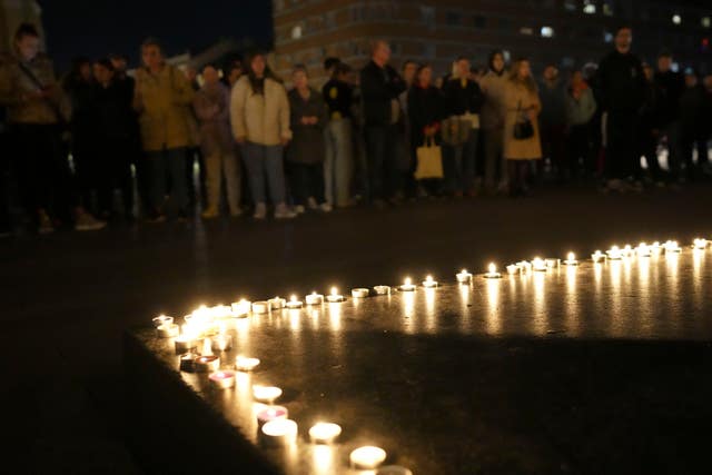 People light candles for the victims of the canopy collapse