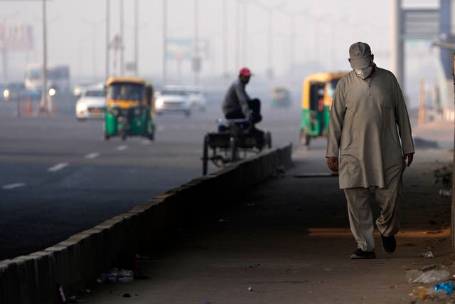 A man wears a face mask by a city street