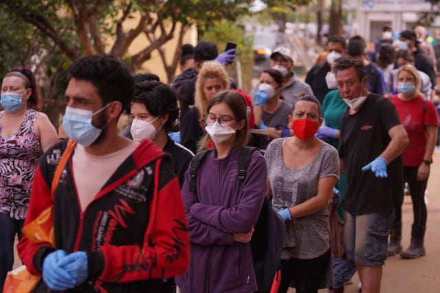 People queue outside a school used as a distribution centre