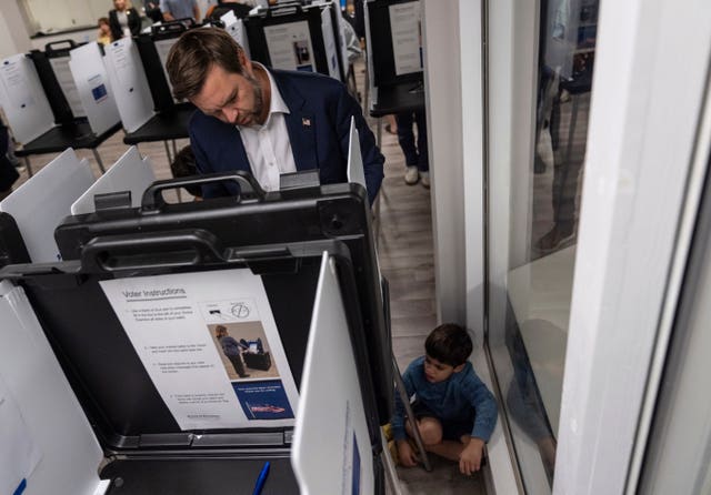 Republican vice presidential nominee Senator JD Vance votes with his son at the St Anthony of Padua Maronite Catholic Church on Election Day in Cincinnati