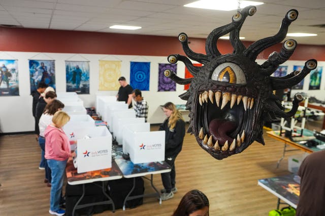 Beholder, a fictional monster in the Dungeons & Dragons fantasy role-playing game, hangs over a voting site as voters cast their ballots on Election Day at The Game Preserve store in Indianapolis