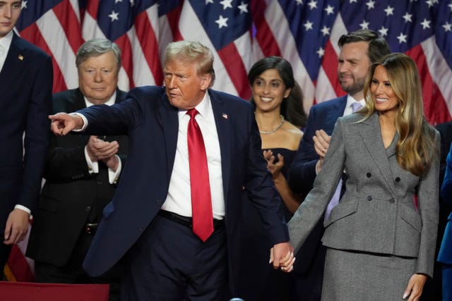 Donald Trump holds hands with former first lady Melania Trump after speaking to supporters in West Palm Beach