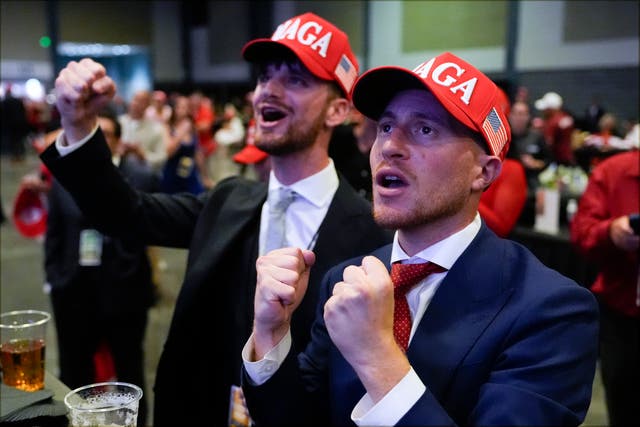 Donald Trump supporters in suits and Maga hats celebrating